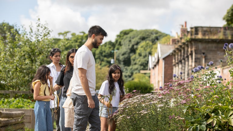 A family looking at flowers in the Kitchen Garden at Seaton Delaval, Northumberland